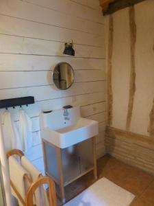 y baño con lavabo blanco y espejo. en La Grange du Turc - Piscine partagée, en Le Mas-dʼAgenais