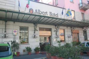 un ingresso a un hotel segnalato con bandiere su un edificio di Albert Hotel a Milano