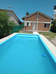 una piscina azul frente a una casa en Flor Silvestre en Valle Hermoso