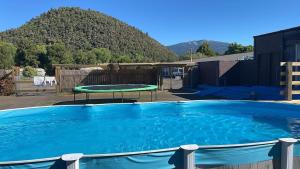 a large blue pool with a table and a trampoline at Oasis Motel & Holiday Park Turangi in Turangi