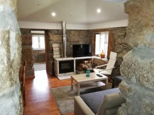 a living room with a stone wall at Casa Da Calçada in Castelo de Paiva