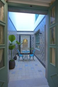 um pátio com cadeiras azuis e uma mesa num pátio em Dar Hammamet Guest House & Hammam em Hammamet