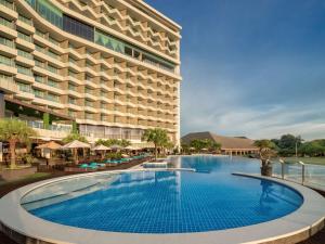 a hotel with a large swimming pool in front of a building at Radisson Golf & Convention Center Batam in Batam Center