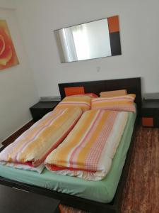 a bed with colorful blankets on top of it at Schöne Wohnung mit WiFi und parkplatz auf der Straße in Oliva