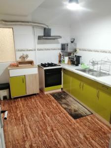 a kitchen with yellow cabinets and a stove at Schöne Wohnung mit WiFi und parkplatz auf der Straße in Oliva