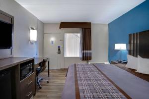 バーリントンにあるMotel 6 Burlingtonのベッドとデスクが備わるホテルルームです。