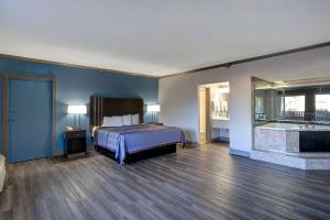 a bedroom with a bed and a bathroom with a tub at Motel 6 Burlington in Burlington