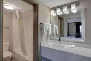 a bathroom with a sink and a toilet and a mirror at Motel 6 Burlington in Burlington +17 photos