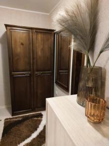 a room with wooden cabinets and a vase with feathers at Dream Apartment in Bansko