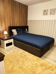 a bedroom with a large bed with a blue bedspread at Dream Apartment in Bansko
