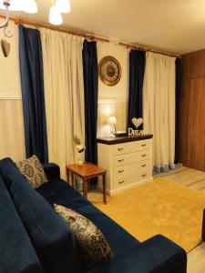 a living room with a blue couch and a dresser at Dream Apartment in Bansko