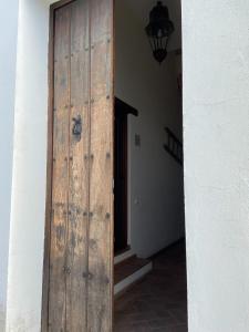 a wooden door leading into a room with a staircase at Dúplex con piscina en centro Cazalla in Cazalla de la Sierra