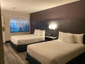 una camera d'albergo con due letti e una finestra di La Quinta Inn by Wyndham Bakersfield South a Bakersfield