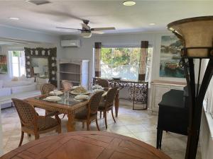 a dining room and living room with a table and chairs at Siesta Key Waterfront Estate W Pool Privacy! in Sarasota