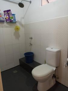 a bathroom with a white toilet and a blue bucket at Homestay uuc in Kota Kinabalu