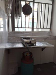 a kitchen counter with a stove and a window at Homestay uuc in Kota Kinabalu