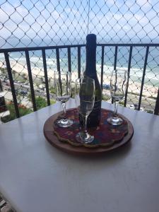 a table with two glasses and a bottle of wine at Flat 2 suites com vista para o mar e lagoa. in Rio de Janeiro