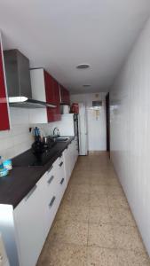 una cocina con armarios blancos y paredes rojas y blancas. en Habitaciones en alquiler en piso compartido en Valencia