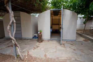 an entrance to a white building with a tree at Camping Koula in Parikia