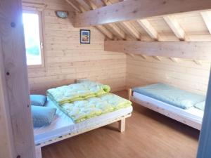 a room with two beds in a log cabin at Lovely chalet in Vosges with shared pool in Zhezdi