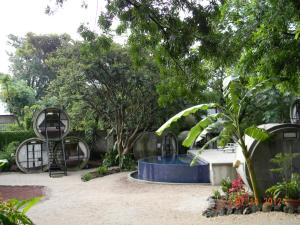 a garden with a blue fountain and trees at Tubohotel in Tepoztlán