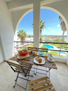 a table with food on it with a view of a pool at Apartamentos Ninho das Gaivotas in Albufeira