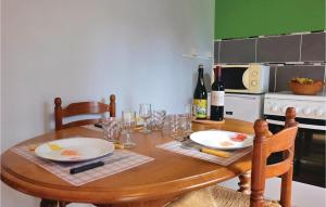 a wooden table with two plates and wine glasses at Beautiful Home In Hames-Boucres in Hames-Boucres