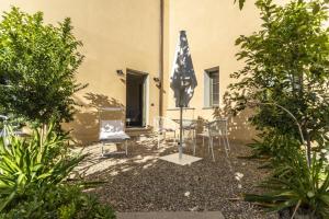 a patio with a table and chairs and an umbrella at Villa Petriolo in Cerreto Guidi