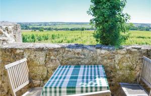 una mesa y sillas en una pared de piedra con vistas en Pet Friendly Home In St Jean Des Mauvrets With Kitchen, en Saint-Mélaine-sur-Aubance