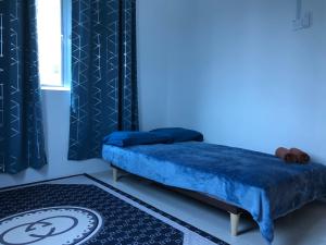 a blue bedroom with a bed and a window at CASA IDAMAN - Islamic Homez in Melaka