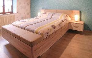 a bed with a wooden frame in a bedroom at 5 Bedroom Awesome Home In Louzy in Magé
