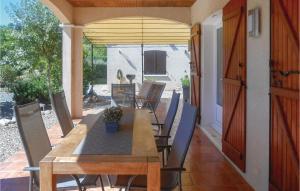 Une table et des chaises en bois sont disponibles sur la terrasse. dans l'établissement Beautiful Home In Prades Sur Vernazobre With Outdoor Swimming Pool, à Prades-sur-Vernazobre