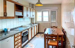 eine Küche mit einem Tisch, einem kleinen Tisch und Stühlen in der Unterkunft Amazing Apartment In Muxa With House Sea View in Muxia