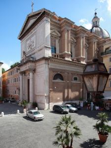 un gran edificio con coches estacionados frente a él en Guesthouse Coronari Courtyard, en Roma