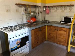 a kitchen with a stove and a sink at Chepoya Apart in Posadas