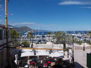 a patio with tables and chairs and a marina at L'Oursin in Saint-Jean-Cap-Ferrat