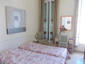 Un dormitorio con una cama y dos sillas. en L'Oursin, en Saint-Jean-Cap-Ferrat