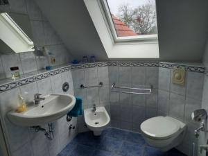 ein Bad mit einem Waschbecken, einem WC und einem Fenster in der Unterkunft Alte Reihe 10 Whg 5 - a57737 in Zingst