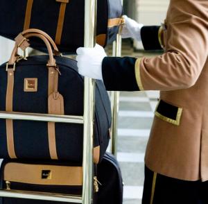 
a woman wearing a suit and tie standing next to luggage at Europe Hotel in Minsk
