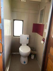 a small bathroom with a toilet and a window at Platform One in Metung
