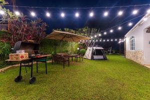 eine Terrasse mit einem Tisch, einem Sonnenschirm und einem Zelt in der Unterkunft 25P Enchanting Bungalow Retreat - Mystical Garden,Petaling Jaya by Verano in Petaling Jaya + 45 Fotos