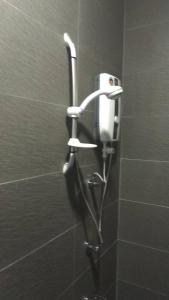 a shower stall with a phone on a wall at Gem Hotel Nusa Sentral Nusajaya in Johor Bahru