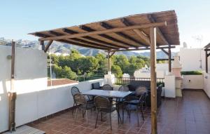 a patio with a table and chairs under a pergola at Beautiful Home In Nerja With 3 Bedrooms, Wifi And Outdoor Swimming Pool in Nerja