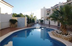 a swimming pool in front of a building with a palm tree at 3 Bedroom Awesome Home In Nerja in Nerja