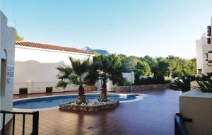 a swimming pool with two palm trees next to a building at 3 Bedroom Awesome Home In Nerja in Nerja +20 photos