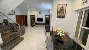 ein Wohnzimmer mit einer Treppe und einem Tisch mit Blumen darauf in der Unterkunft HOTEL FRIDAY INN in Yercaud