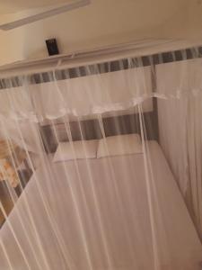 1 dormitorio con cortinas blancas en una ventana en Aira Place, en Weligama