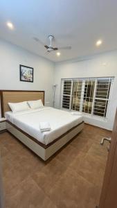 een slaapkamer met een groot wit bed en een aantal ramen bij HOTEL FRIDAY INN in Yercaud +32 foto's