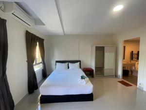 1 Schlafzimmer mit einem großen weißen Bett und einem Badezimmer in der Unterkunft Tiara Desaru Seaview Residence in Desaru
