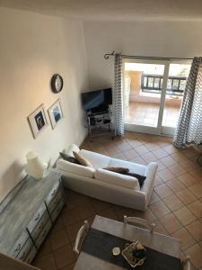 een woonkamer met een witte bank en een televisie bij Seahouse Portorotondo in Porto Rotondo
